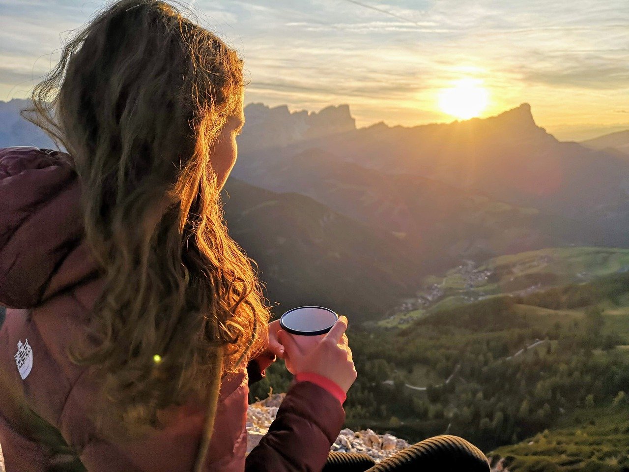 mujer en montaña bebiendo café viendo el medio ambiente