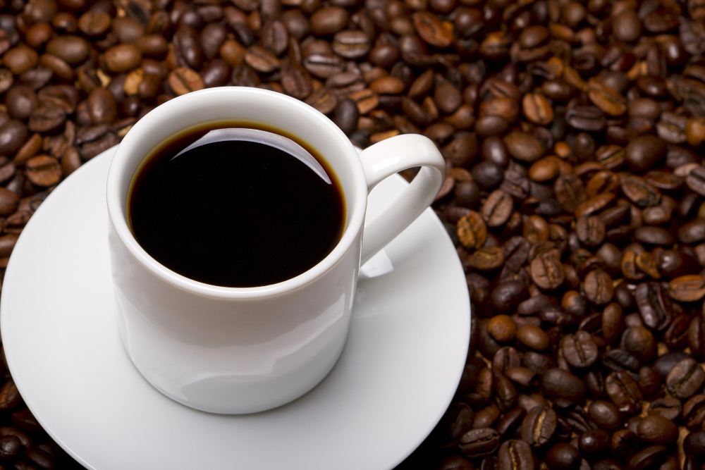 taza de café negro alrededor granos de café
