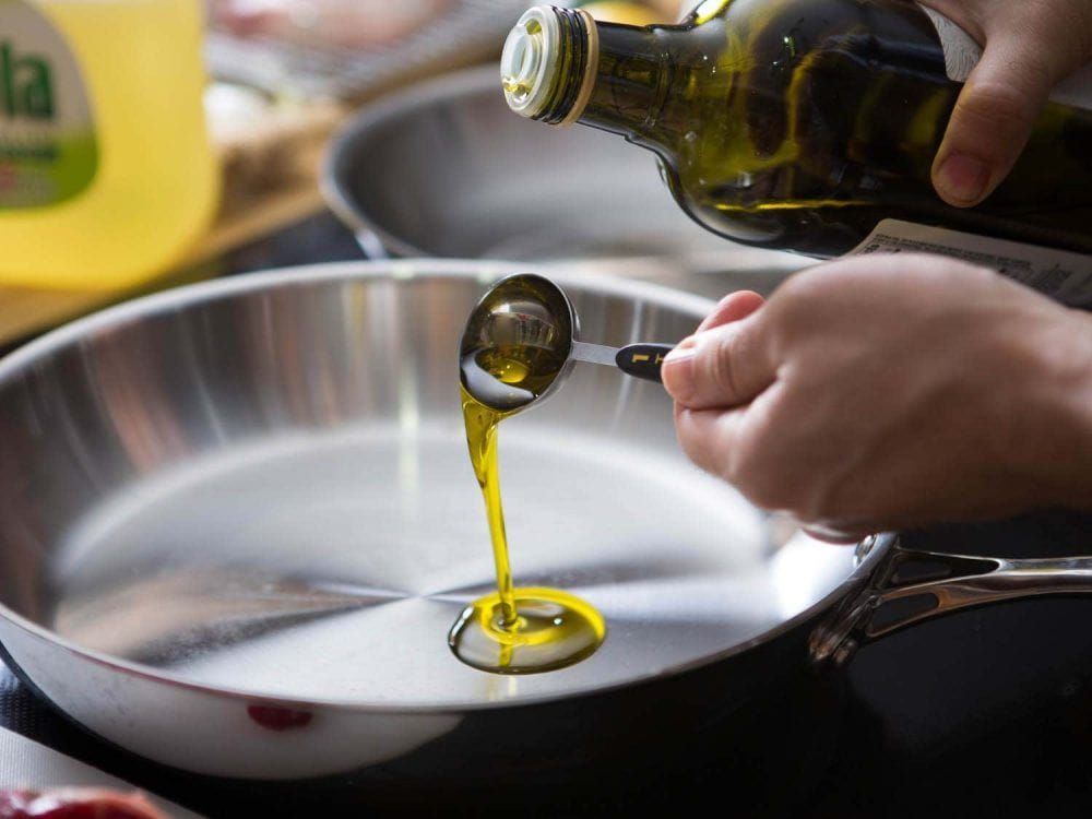 sirviendo aceite de oliva en sarten